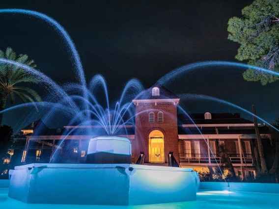 Old Main with fountain in foreground, at night with dramatic lights