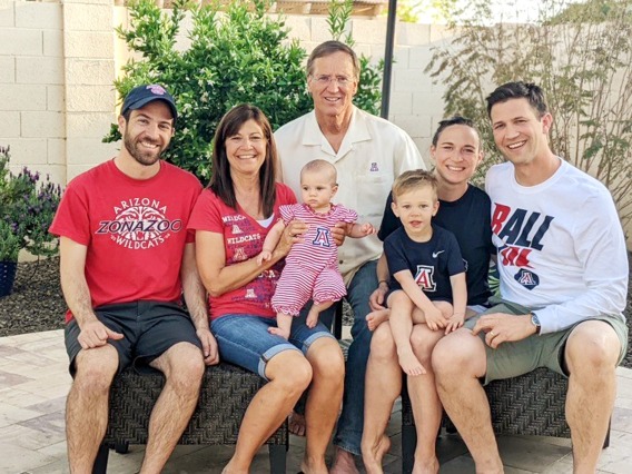 A photograph of Mike and Sheri Hummel sporting UArizona gear with their sons and grandchildren. 