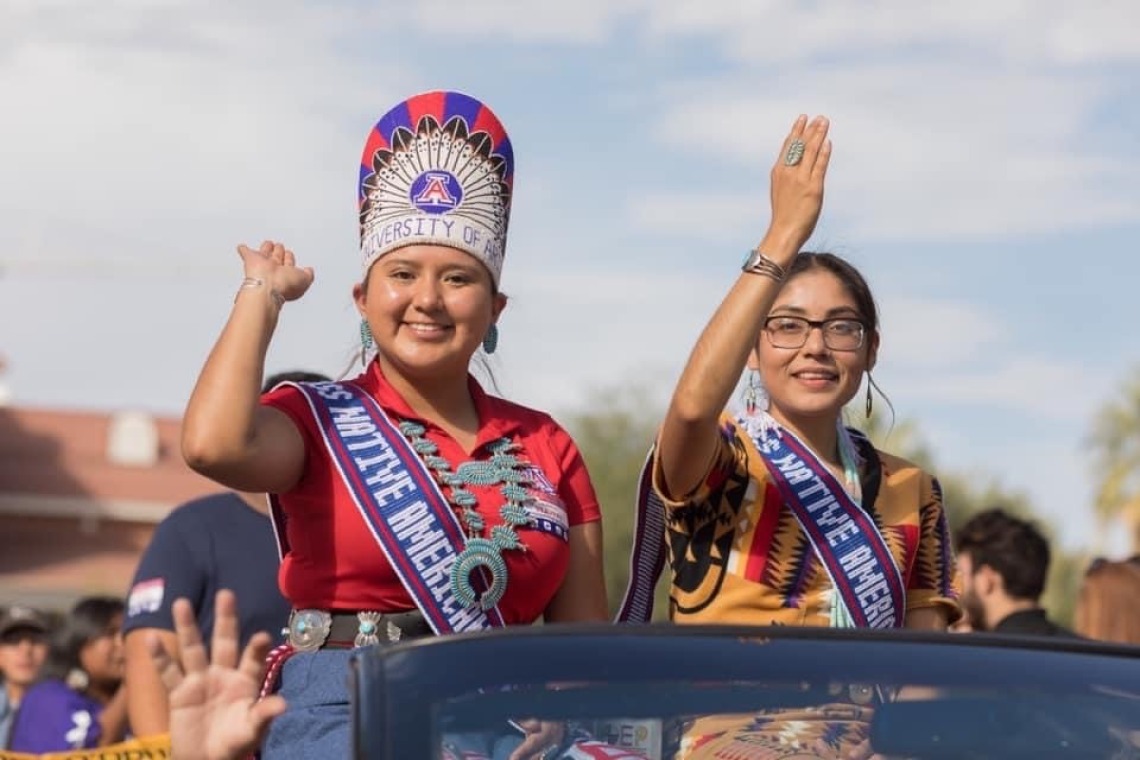 Two women in Native American dress, waving