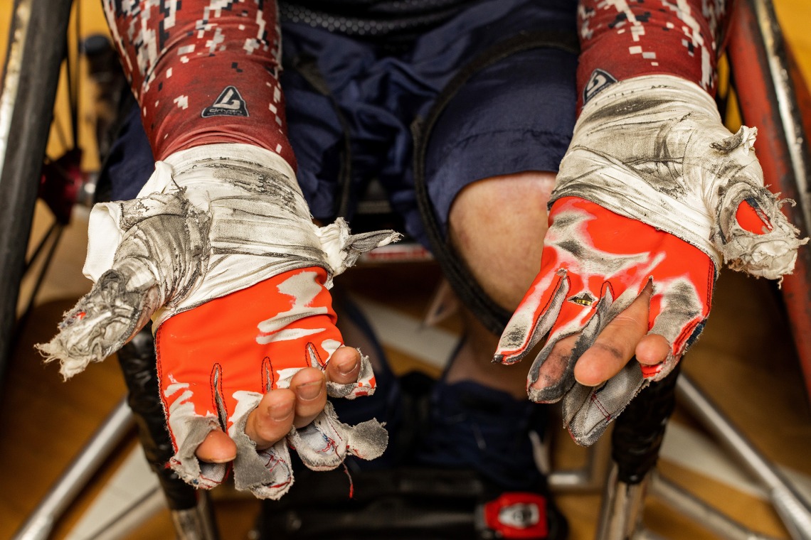 Close-up of a wheelchair rugby player's ripped and dirty gloves