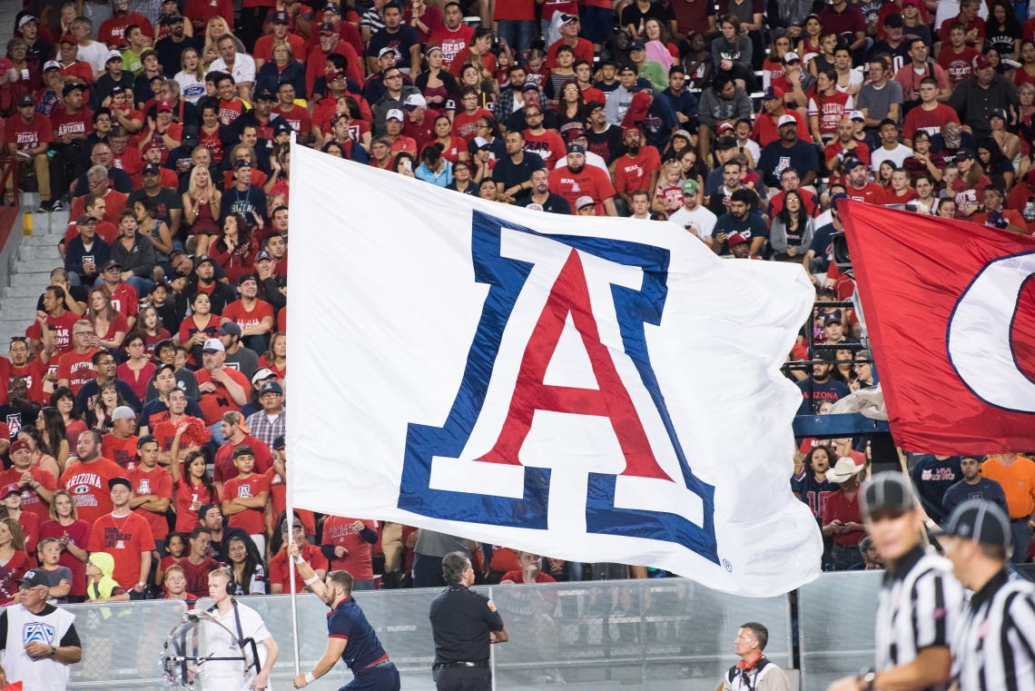 Cheerleader carrying large "A" flag