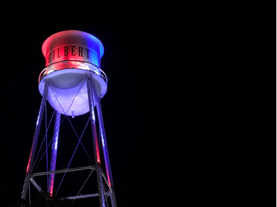 A photograph of the Gilbert Water Tower shining with red and blue lights