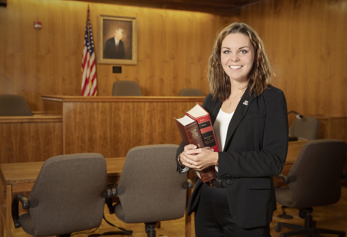 A photograph of Amanda Higby smiling in a court room