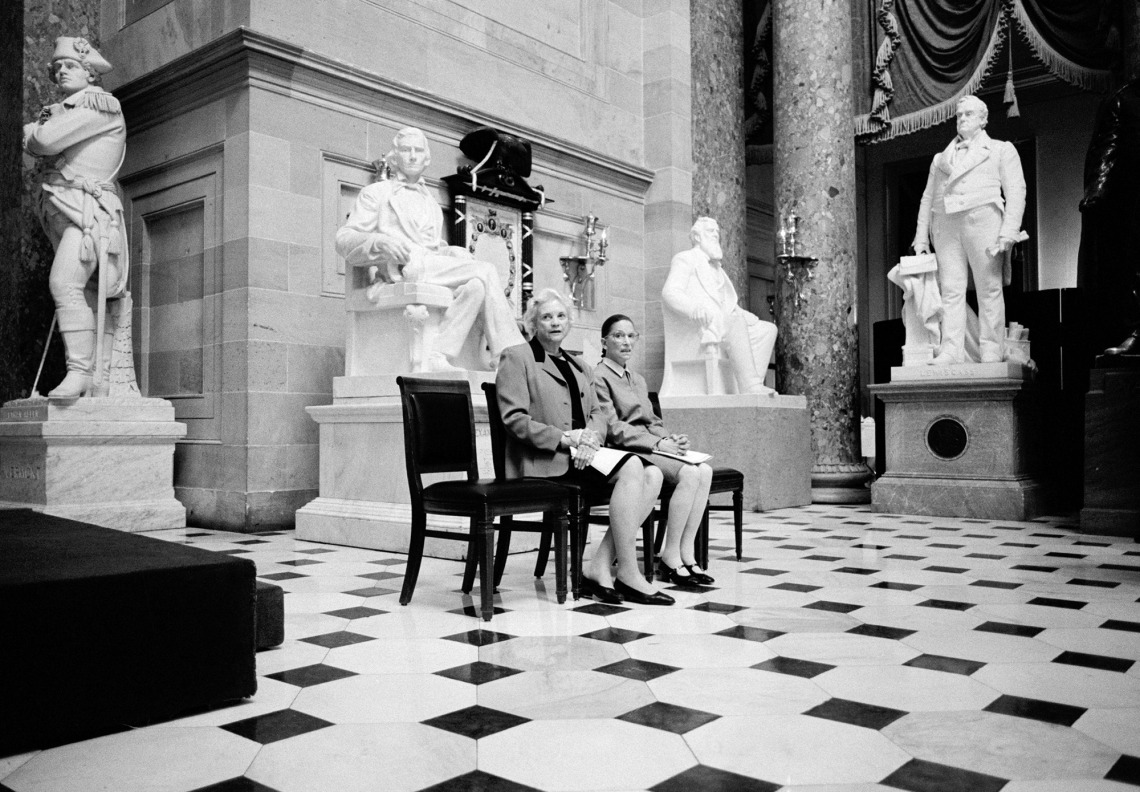 A photograph of Justices Sandra Day O’Connor and Ruth Bader Ginsburg sitting on a bench in Statuary Hall in the U.S. Capitol