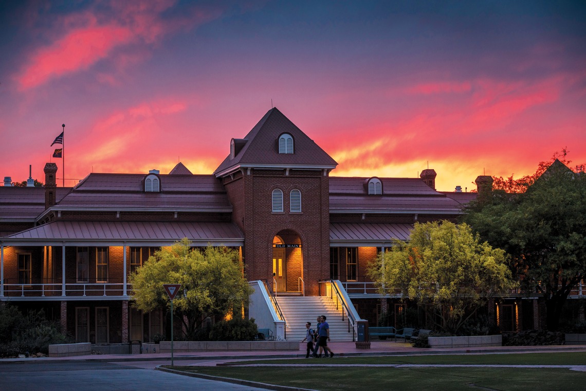A photograph of Old Main at sunset