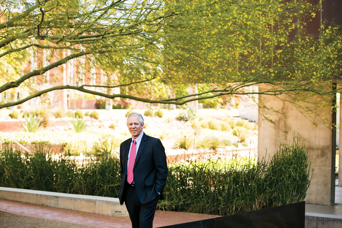 A photograph of Dr. Robert C. Robbins standing on the University of Arizona campus