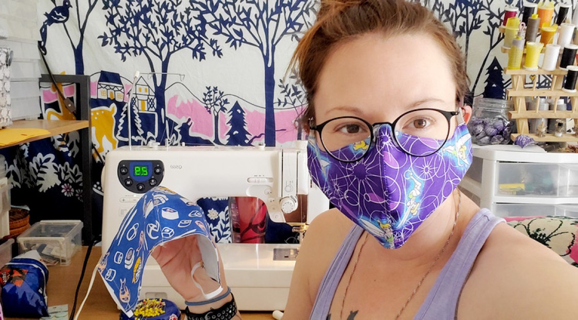 A photograph of Rachel Wilkins wearing and posing with a homemade mask