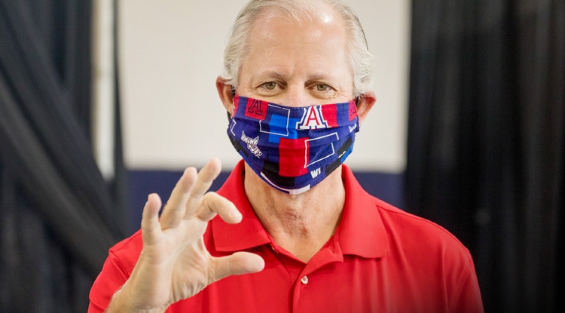 A photograph of President Robbins, M.D. wearing a wildcat-themed mask