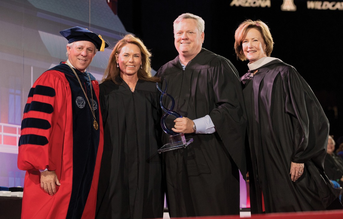 A photograph of UA President Robert C. Robbins, Sharon and Jeff Stevens, and Melinda Burke in graduation regalia