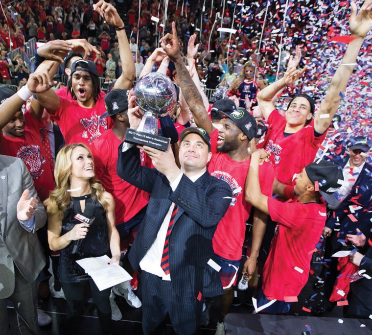 A photograph of Sean Miller and his team cheering at the PAC-12 championship after a big win
