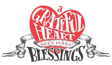 An illustration of red heart that has the words "A Grateful Heart Sees Many Blessings" with a banner across it