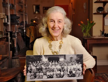 A photograph of Natalie Auster Levinson holding a black and white photograph
